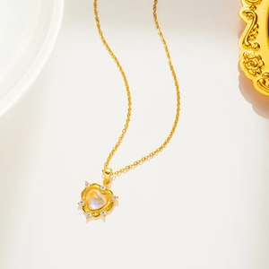 Golden heart pendant necklace with moonstone and sparkling diamonds on white surface