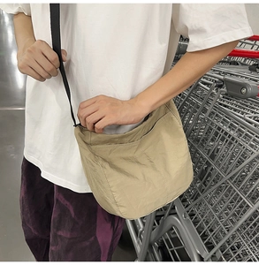 Close-up of khaki nylon messenger bag with adjustable strap and detailed stitching