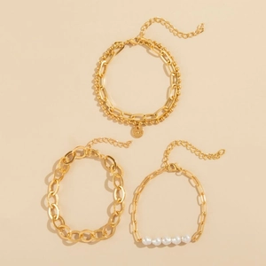 Layered gold bracelets with Love charm and pearls shown from a top-down view