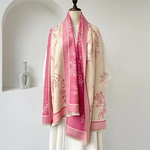 Texture détaillée de l'écharpe en cachemire rose et beige avec motifs floraux et franges