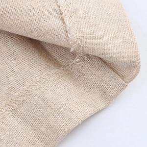 Dettaglio della trama in lino beige e della cucitura taglia-cuci di alta qualità del capo