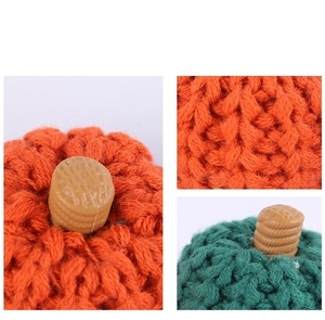 Detailed close-up of handmade knitted pumpkins with rich textures and spiral stems