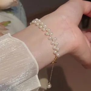 Élégant bracelet tressé à double rangée de perles avec chaîne dorée au poignet
