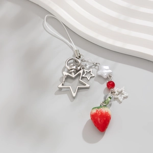 Dettaglio del ciondolo fragola con stelle argentate e perline su un cordino minimalista