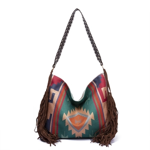 Detail of bohemian shoulder bag featuring geometric patterns and brown side fringes