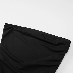 Gros plan sur les détails froncés et la texture du tissu élastique d'une robe noire moulante