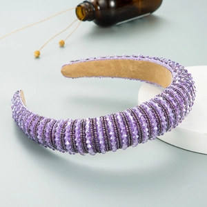 Detail eines lila Perlenstirnbands mit Kristalltextur und khakifarbenem Wildlederfutter