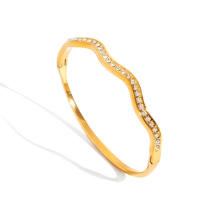 Detail of 18K gold plated stainless steel wave bangle with pavé inlaid crystals
