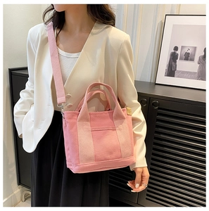 Pink canvas tote bag with adjustable strap shown on model in white blazer and black skirt