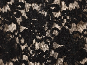 Gros plan sur un tissu en dentelle florale noire avec des motifs ajourés et doublure