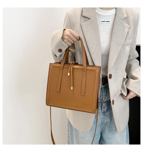 Dettaglio della borsa a tracolla in pelle marrone con design geometrico e coulisse