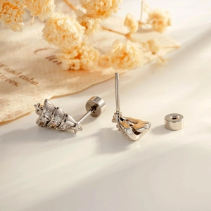 Sparkling silver Christmas tree stud earring with pavé zircon stones on a floral background