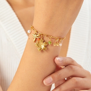 Gold-plated stainless steel charm bracelet with cherry, dragonfly, flower and pearls on wrist
