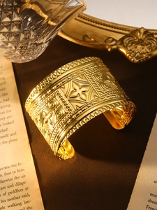 Nahaufnahme des goldenen Bohemian-Manschettenarmbands mit floralen und geometrischen Mustern