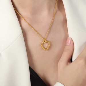 Collier chic avec pendentif cœur doré sur mannequin en blazer blanc épuré