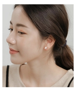 Close-up of a silver S999 star-shaped earring worn on a model's earlobe for styling