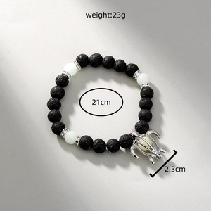 Detailed size view of black lava stone beaded bracelet with glow turtle pendant and specs