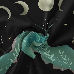 Close-up of bohemian butterfly tapestry with moon phase and green leaf patterns on black fabric