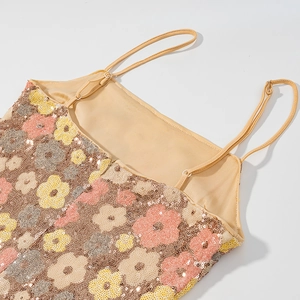Détail de broderie florale à paillettes avec bretelles fines sur robe or champagne