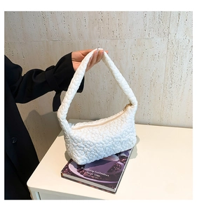 Detail of white quilted cloud handbag with 3D floral texture and gold zipper closure
