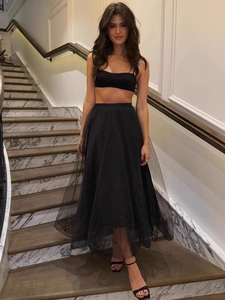 Elegant two-piece black set with slim tube top and puffy mesh maxi skirt on stairs
