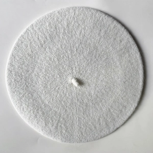 Close-up of white knitted beret featuring delicate spiral texture and top stem detail
