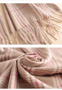 Detailed view of pink plaid cashmere scarf featuring soft fringe and woven wool texture