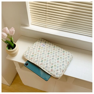 Detail view of handmade quilted cotton floral laptop sleeve featuring a zipper closure