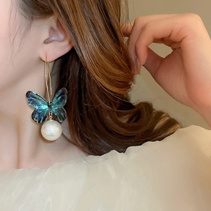 Elegant acrylic butterfly earrings with pearl pendant hanging on long gold hooks