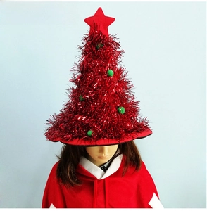 Detail of red tinsel Christmas tree hat featuring green pom-poms and a red star on top