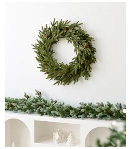 Detail of lush green Christmas wreath and matching garland decorated with pine cones