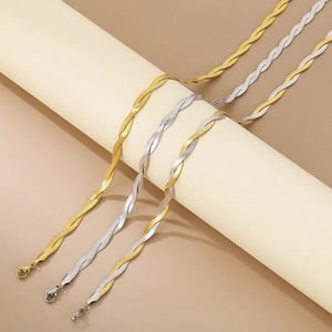 Detailed view of three-tone braided snake bone chain necklaces in gold and silver
