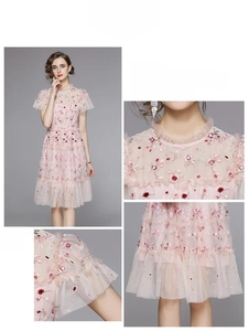 Détail de robe rose en tulle avec broderies florales, sequins et col volanté