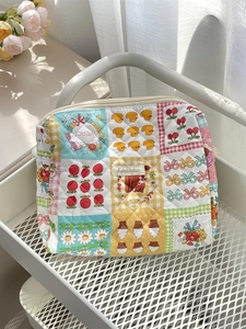 Detailed close-up of a quilted floral makeup bag with colorful patchwork patterns and zip