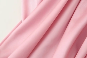 Vista macro del tessuto rosa che mostra pieghe setose e dettagli di tessitura