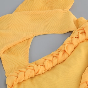 Gros plan sur tissu plissé jaune avec détails de décolleté tissé et texture fine