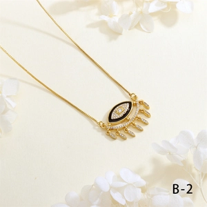 Macro detail of Evil Eye pendant with zircon fringe and gold plated box chain