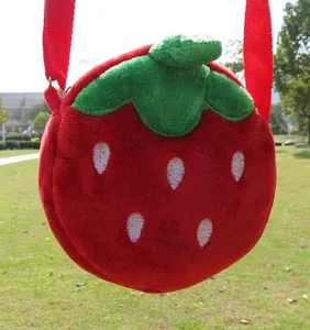 Detail of red plush strawberry crossbody bag with leaf decor and woven shoulder strap
