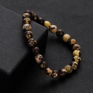 Close-up detail of natural agate beads bracelet on a black display stand with stone texture