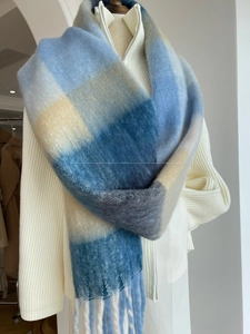 Detailed view of soft plaid shawl featuring fuzzy texture and long fringe tassels
