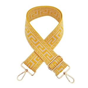 Detail of yellow and white Greek Key patterned woven strap with gold lobster clasps