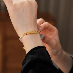 Detail of beaded pearl bracelet with zircon encrusted metal rings on a person's wrist