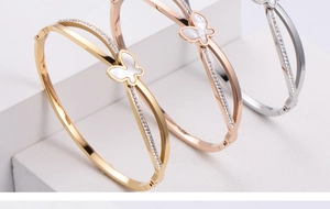 Detailed view of elegant butterfly bangles in gold, rose gold, and silver finishes