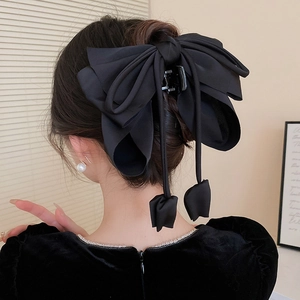 Détail d'une pince à cheveux élégante avec nœud noir en mousseline et prise ferme
