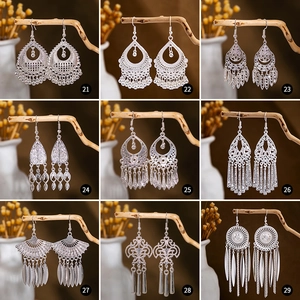 Detailed grid of nine antique silver ethnic earrings with tassel and leaf designs