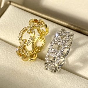Macro detail of gold and silver chain rings with micro-paved rhinestones on a jewelry box