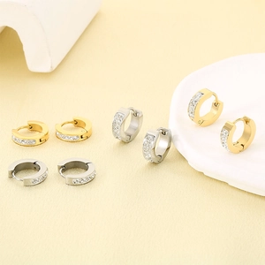 Detail view of gold and silver stainless steel hoop earrings with sparkling rhinestones