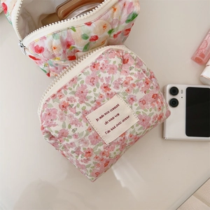 Detailed view of floral quilted cotton makeup bag with zipper and French label