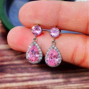 Macro detail of pear-shaped pink zircon drop earring with silver pave setting