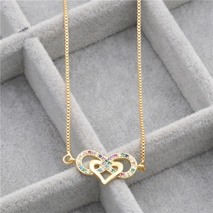 Detail of gold-plated necklace featuring a heart and infinity pendant with colorful zircons